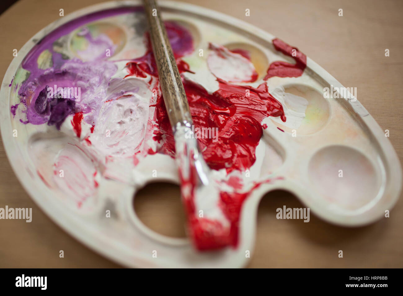 Smeared with the brush in the palette with paints. Red and purple paint Stock Photo