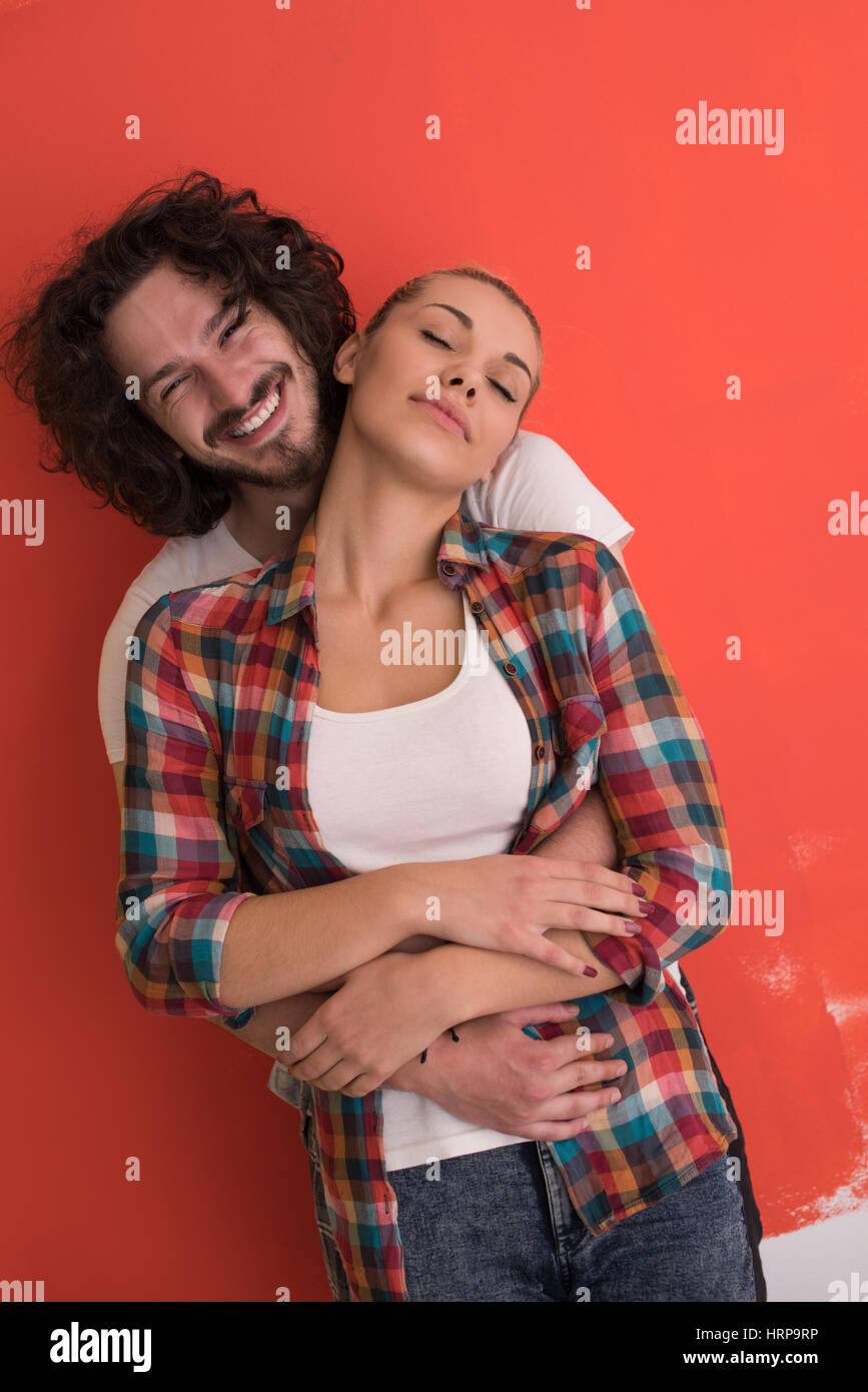 Portrait of a happy young smiling couple in love over color background ...