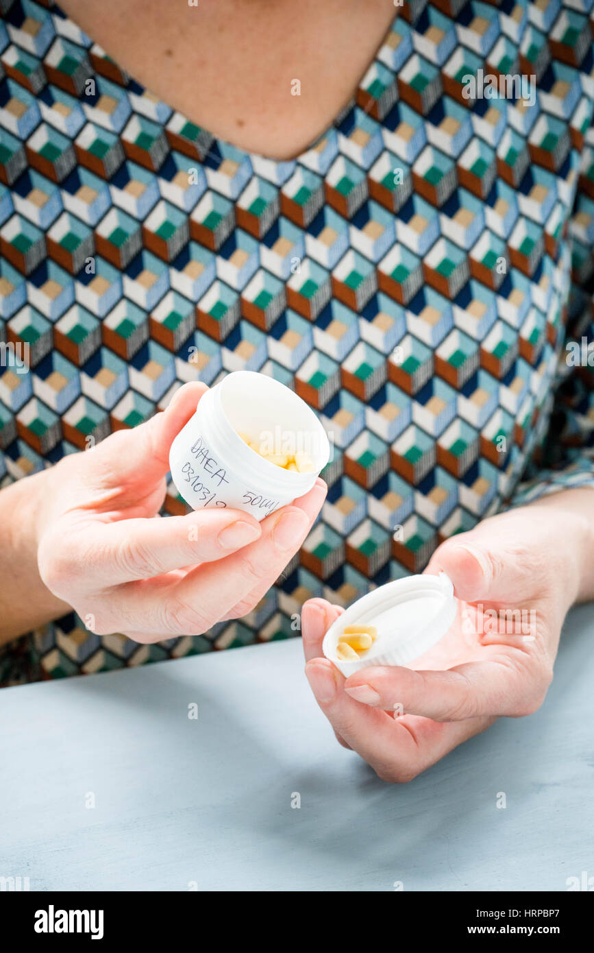 Woman taking DHEA capsules Stock Photo Alamy
