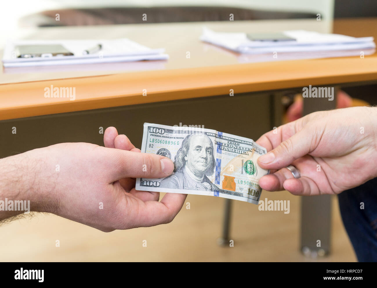 Man offering of hundred dollar bill. Hands close up. Corruption concept.  United States Dollars (or USD). Stock Photo