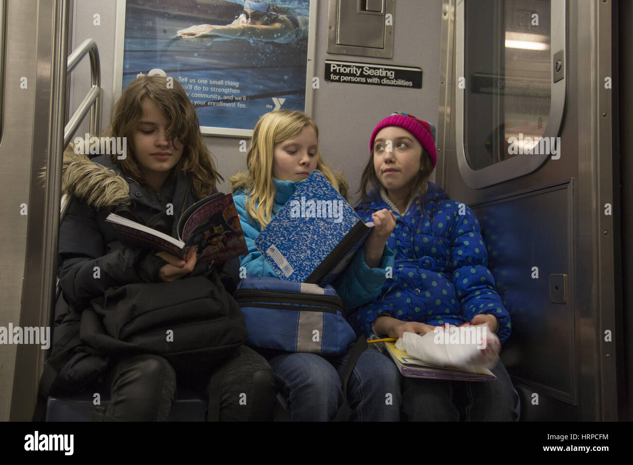 Three friends ride the subway train in New York CIty on their way home