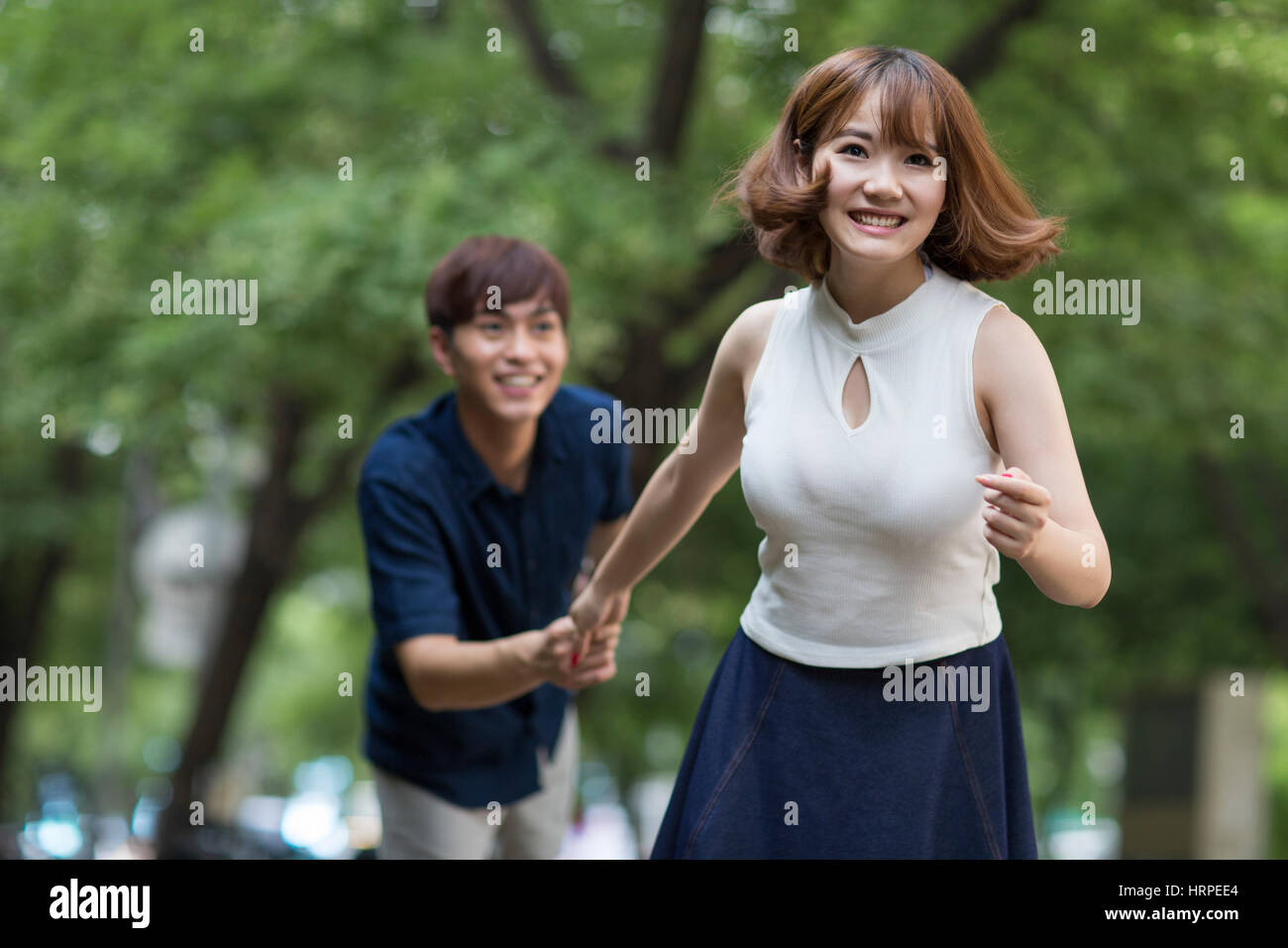 Happy young couple holding hands Stock Photo - Alamy