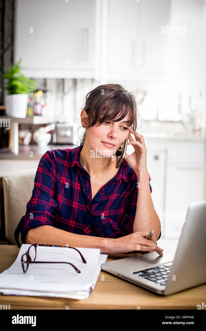 Woman working at computer in home office. Stock Photo