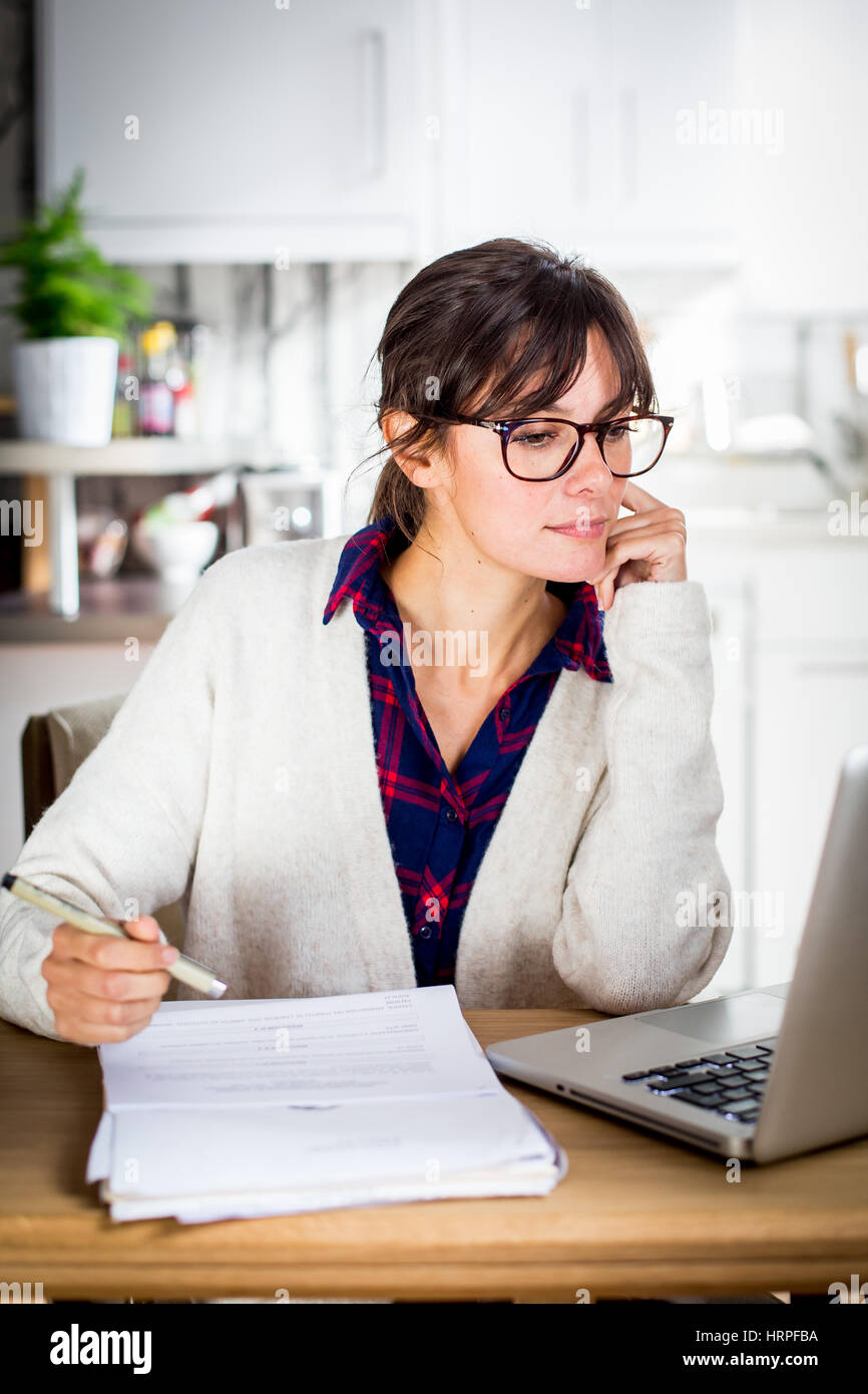 Woman working at computer in home office. Stock Photo