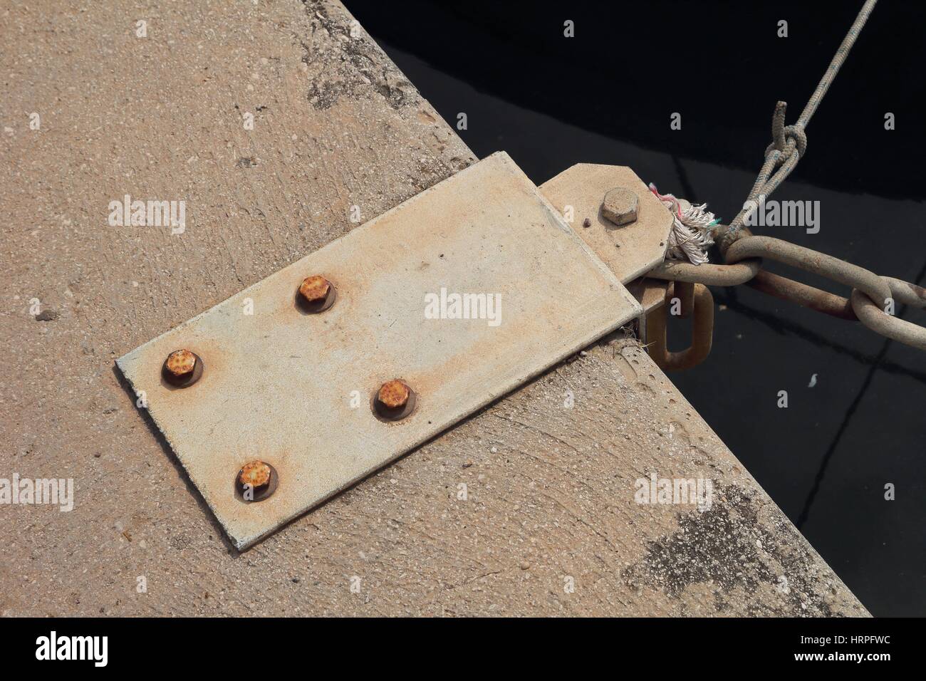 Steel mooring point on quayside with chain attached Stock Photo