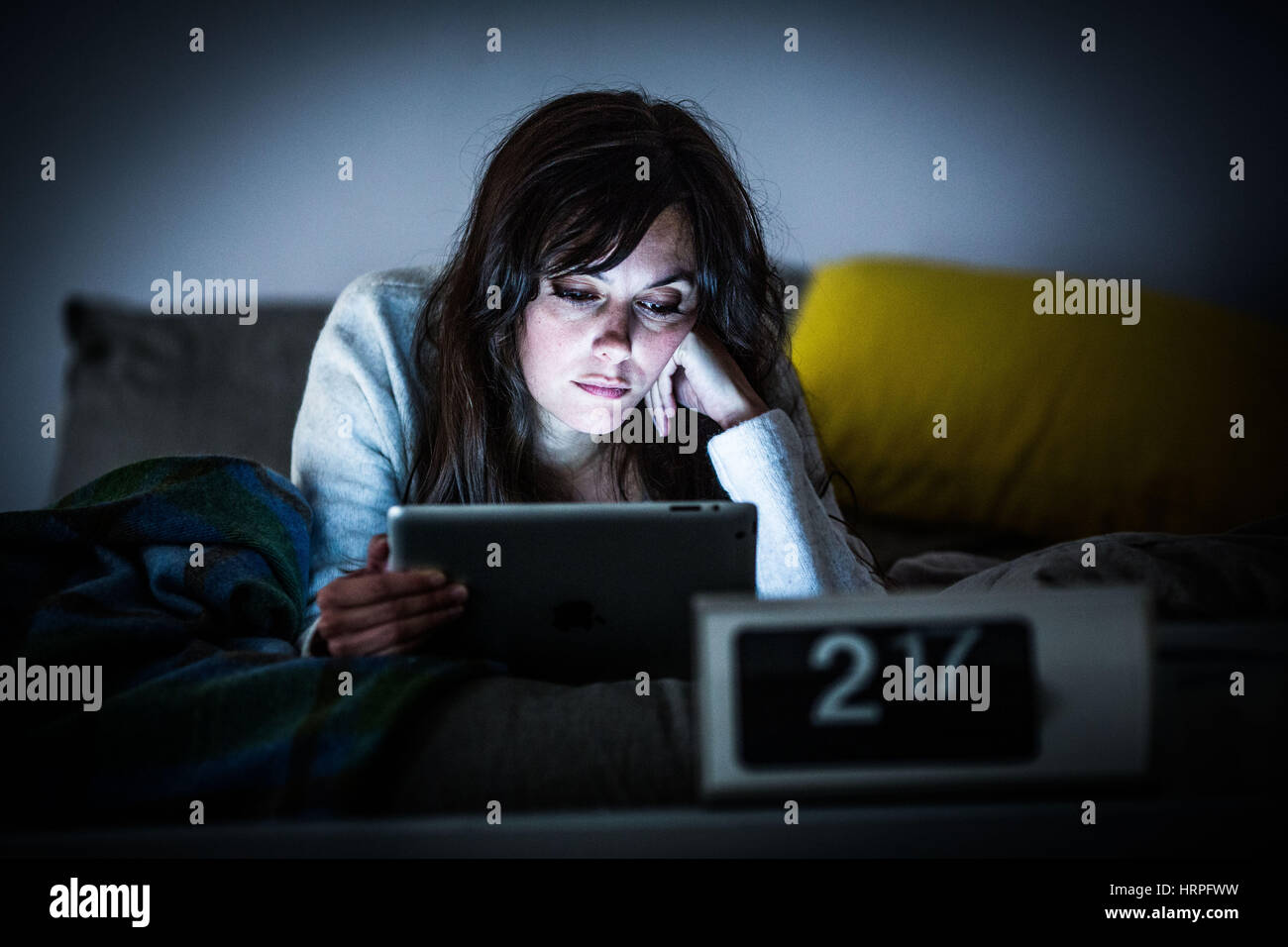Woman using a digital tablet at night. Stock Photo