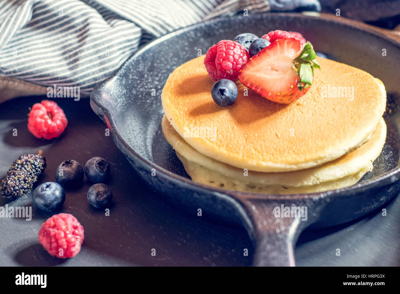 Home made pancakes with berries on metal frying pan decorated with ...