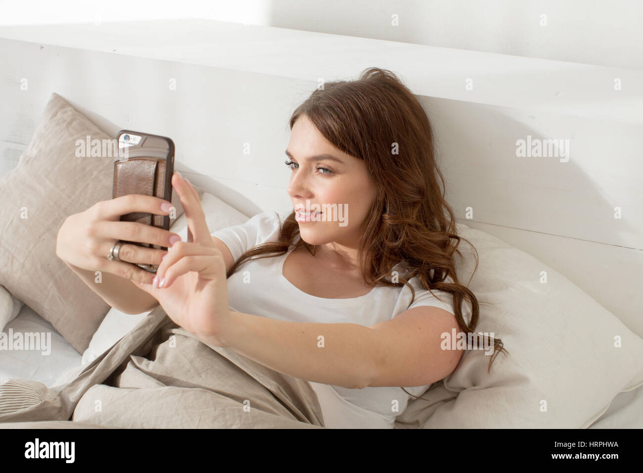 Smiling female taking selfie on her smartphone Stock Photo