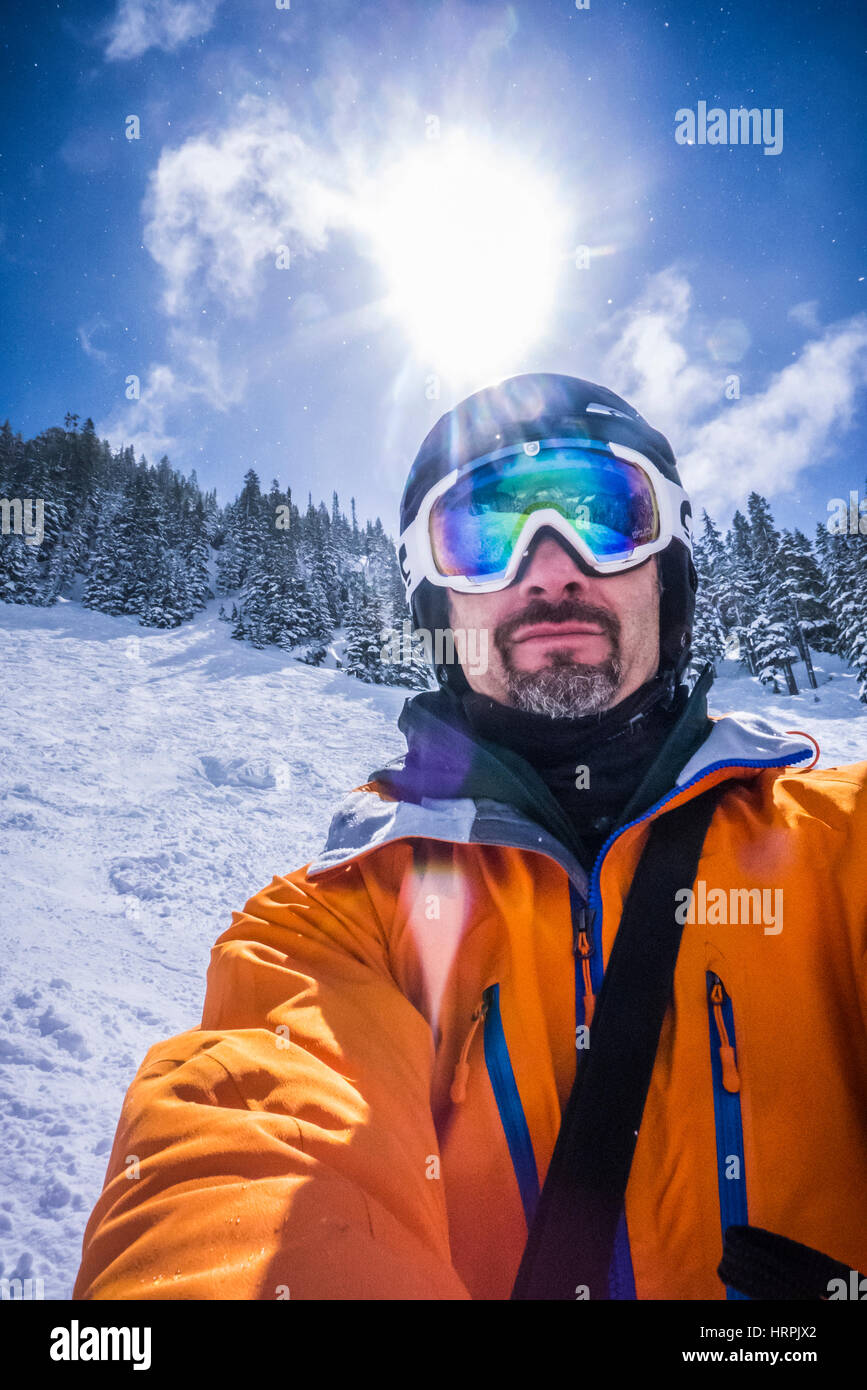 A man with a beard on a ski slope taking a selfie portrait. Stock Photo