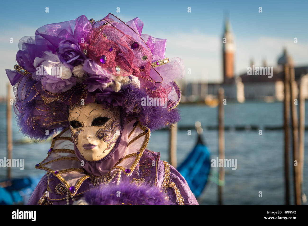 Golden Venetian Carnival Mask. Wonderful mask participant of the carnival celebrations in St. Mark's basin. Blurred background. Stock Photo