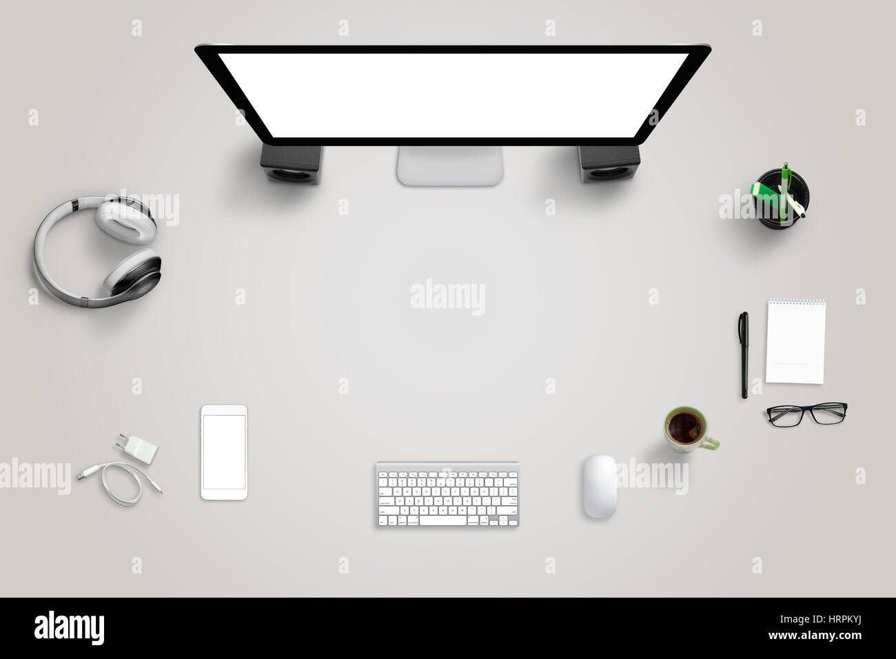 Desk with technology devices with free space for text. Top view of computer display, mobile phone, keyboard, mouse, headset, pad, glasses, coffee, pen Stock Photo