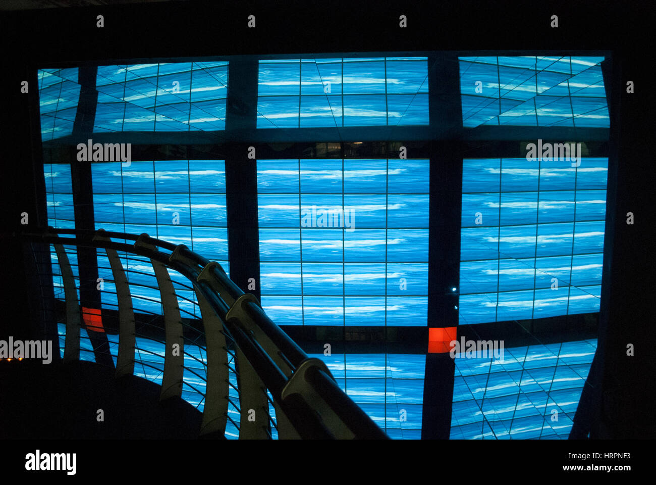 Wall of blue video screens at the Natural History Museum showing the water cycle Stock Photo