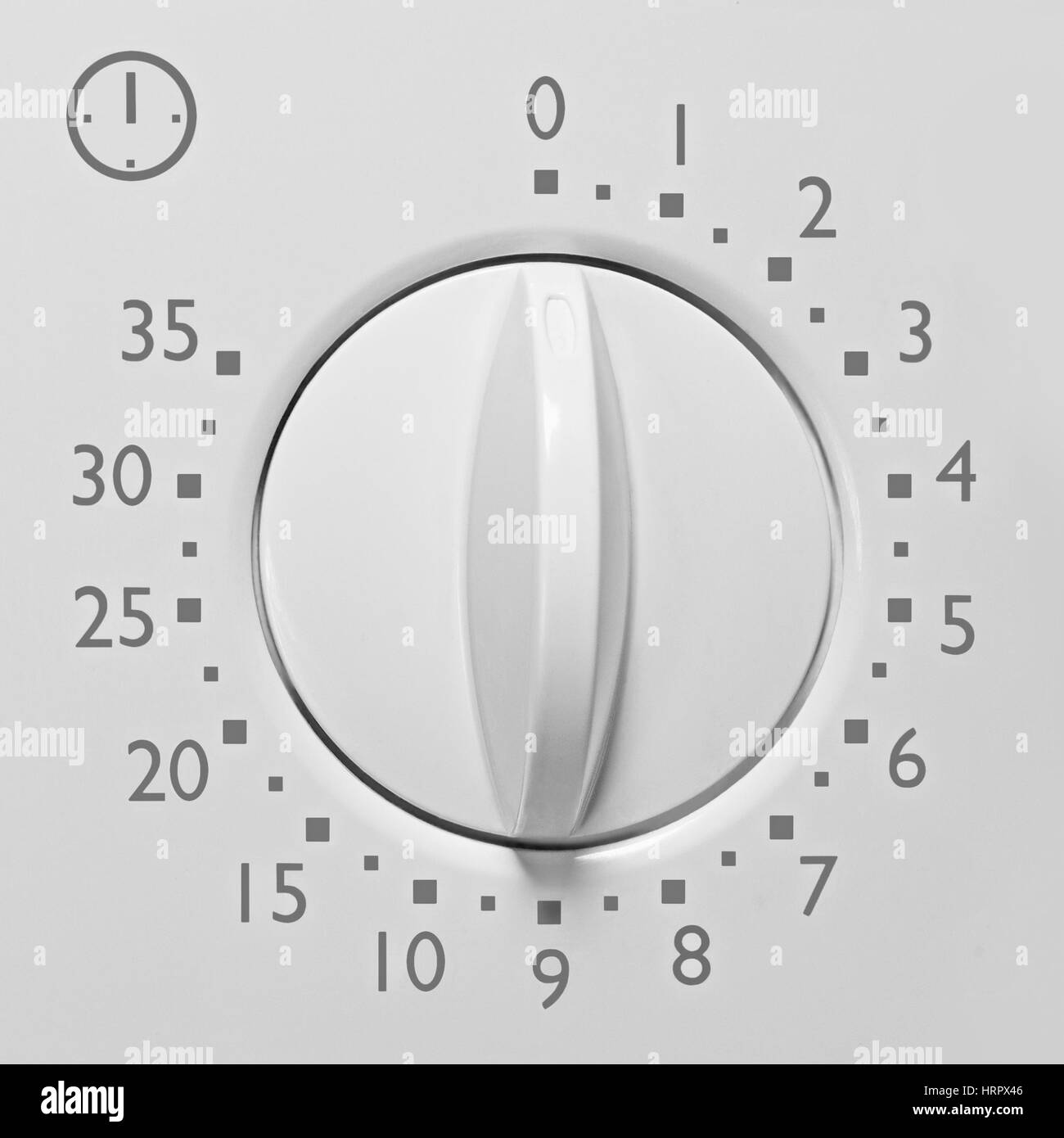 Analog 35 minute microwave oven timer, analogue vintage white dial face macro closeup grey numbers and icon, large background copy space Stock Photo