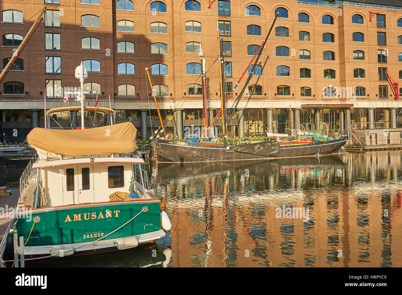 Boats reflected in the waters of regenerated St Katherines Dock in London. Stock Photo