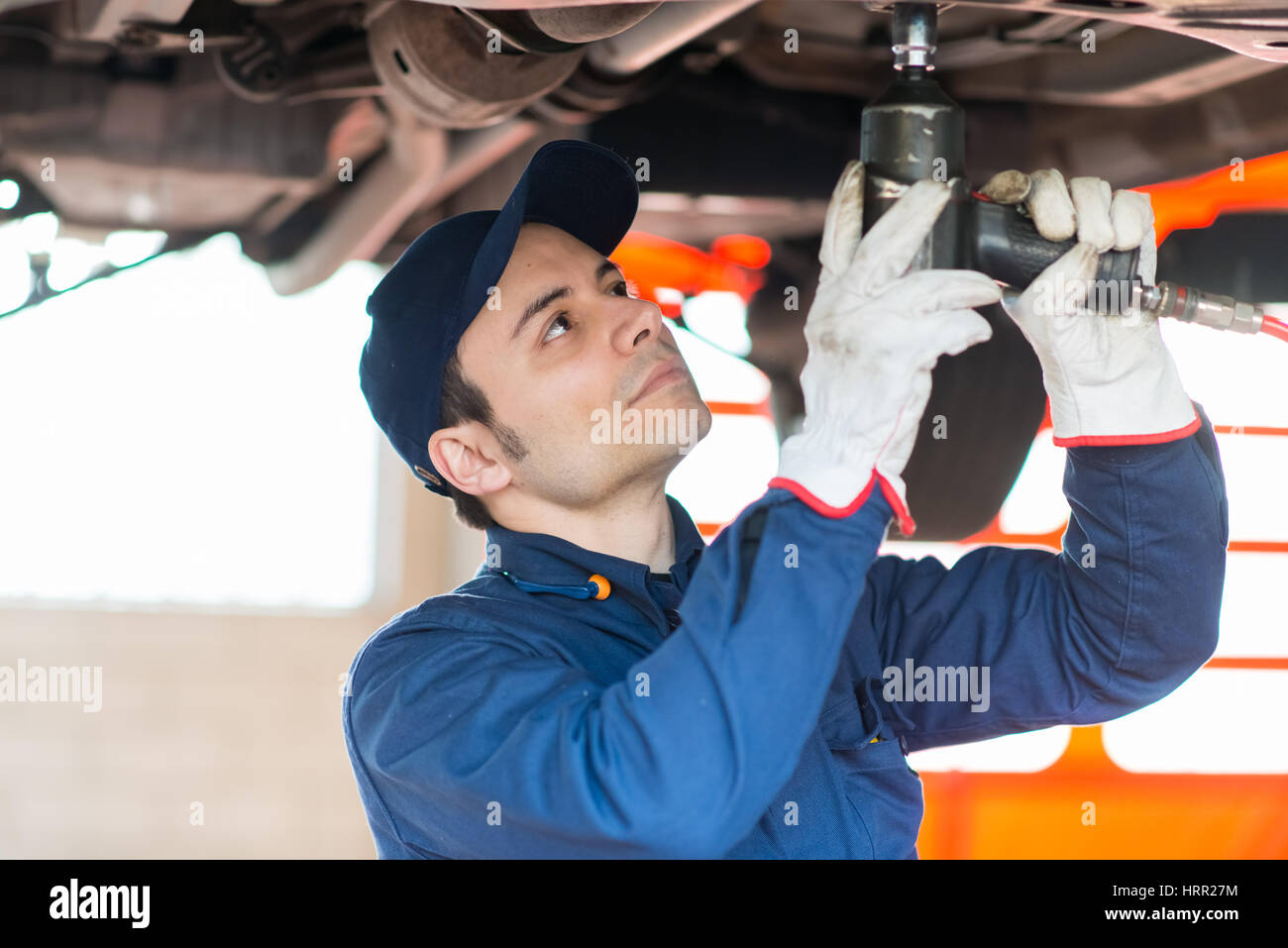 Mechanician changing car wheel in auto repair shop Stock Photo - Alamy
