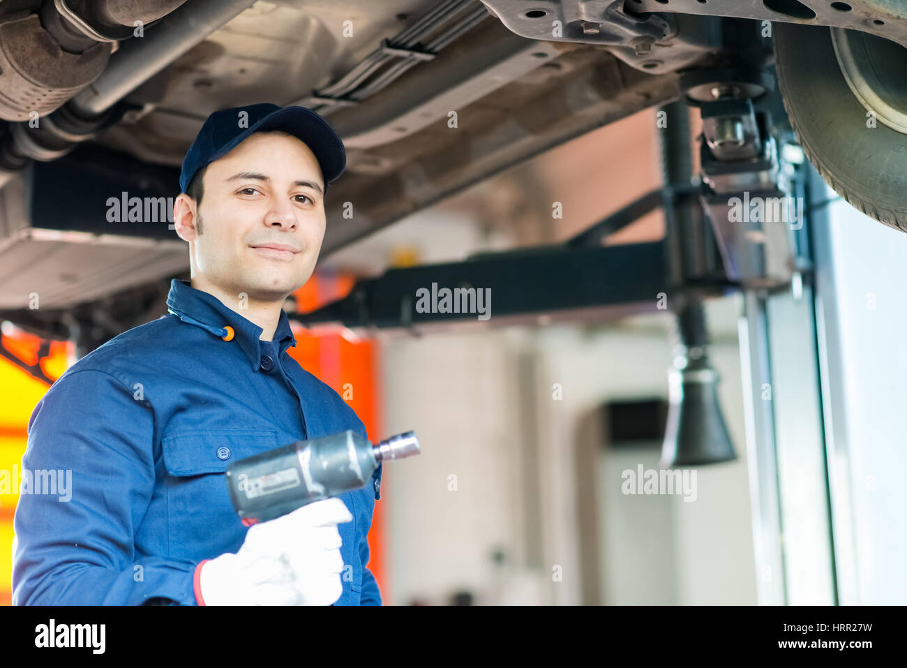 Mechanician changing car wheel in auto repair shop Stock Photo - Alamy