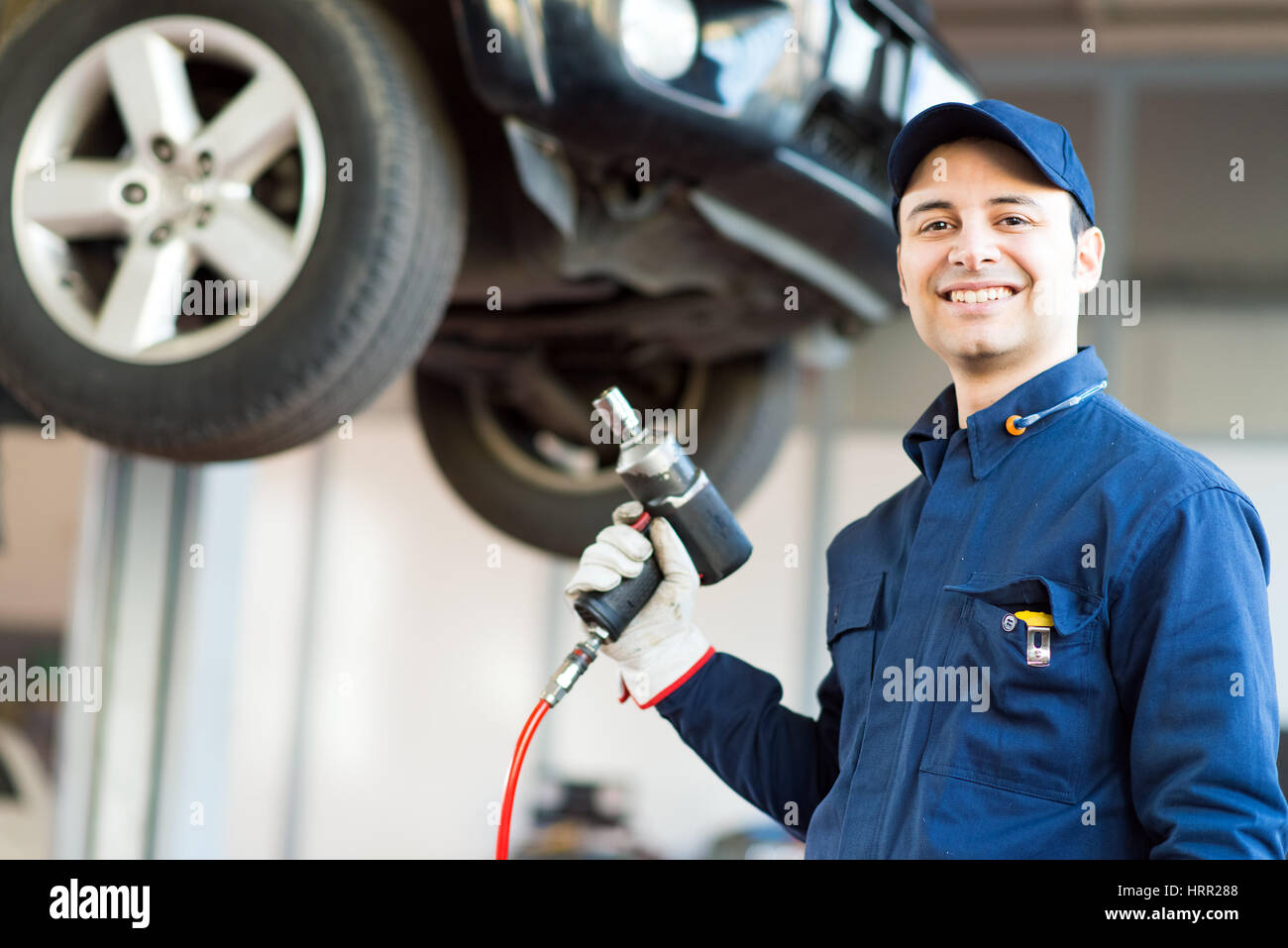 Mechanician changing car wheel in auto repair shop Stock Photo - Alamy