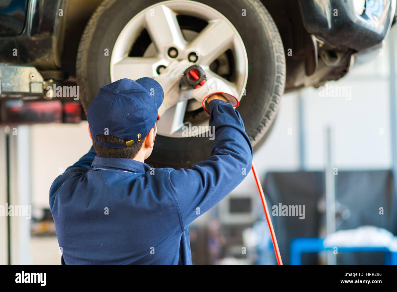 Mechanician changing car wheel in auto repair shop Stock Photo - Alamy