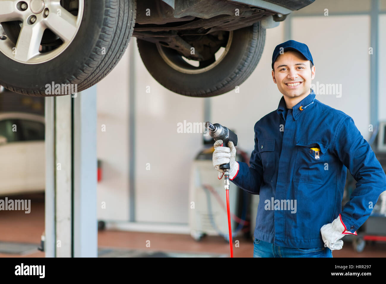 Mechanician changing car wheel in auto repair shop Stock Photo - Alamy