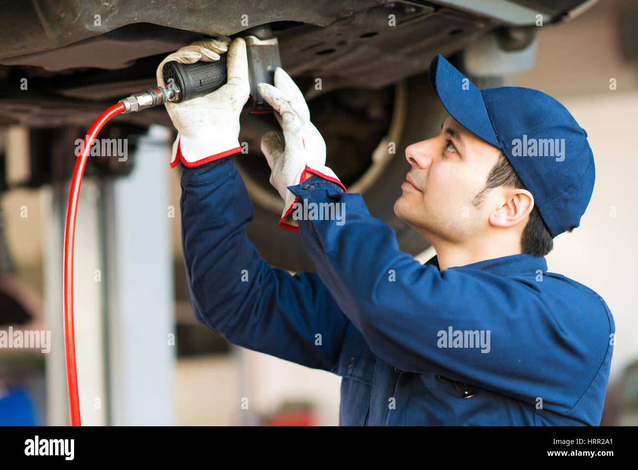 Mechanician changing car wheel in auto repair shop Stock Photo - Alamy