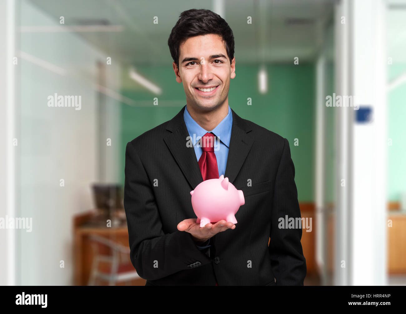 Businessman in black suit holding a piggy bank Stock Photo - Alamy