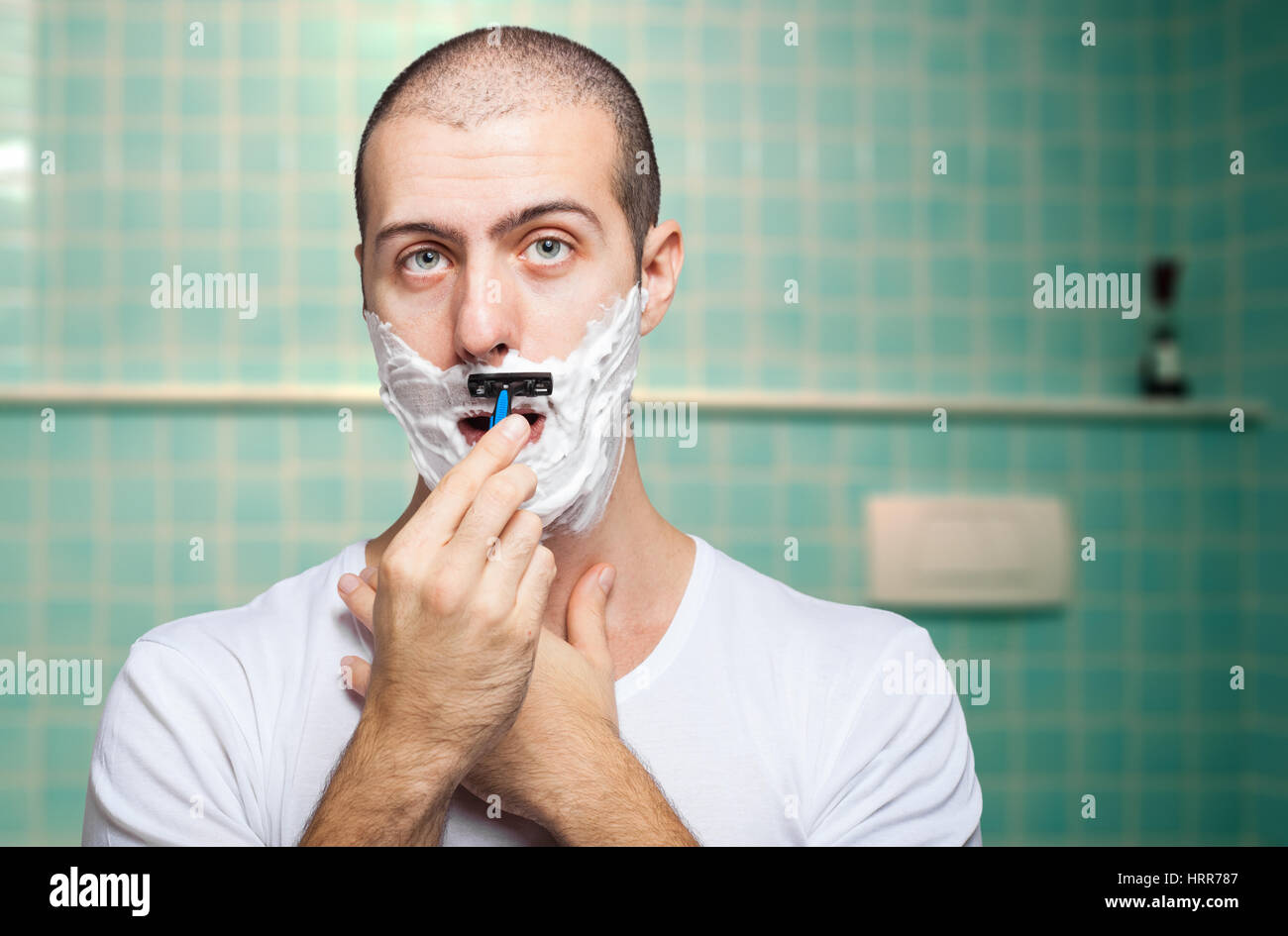 Man using a disposable razor to shave his beard off Stock Photo Alamy