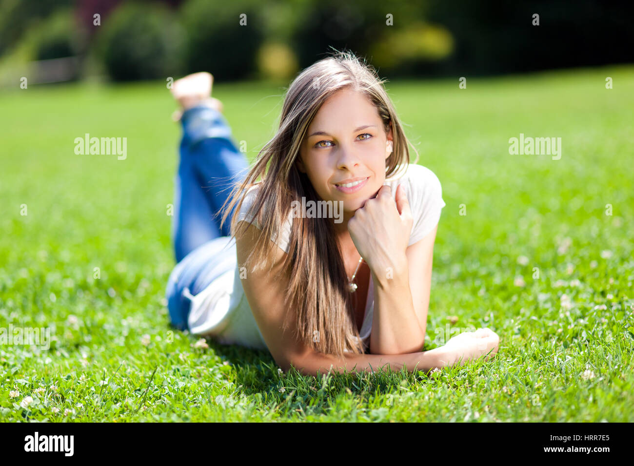 Beautiful woman lying on the grass in the park Stock Photo - Alamy