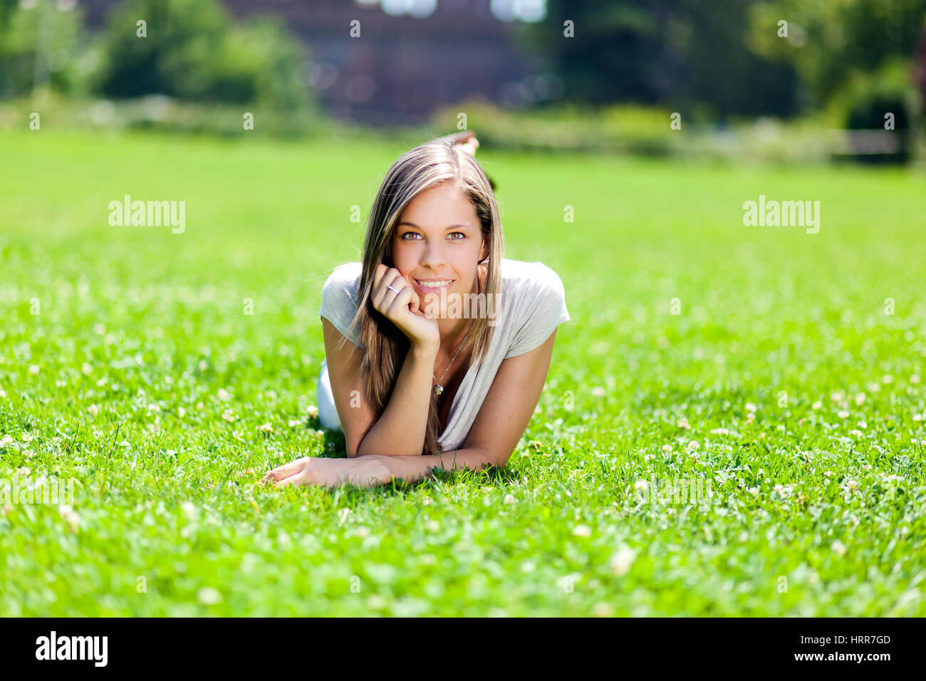 Young smiling woman lying down on the grass Stock Photo - Alamy