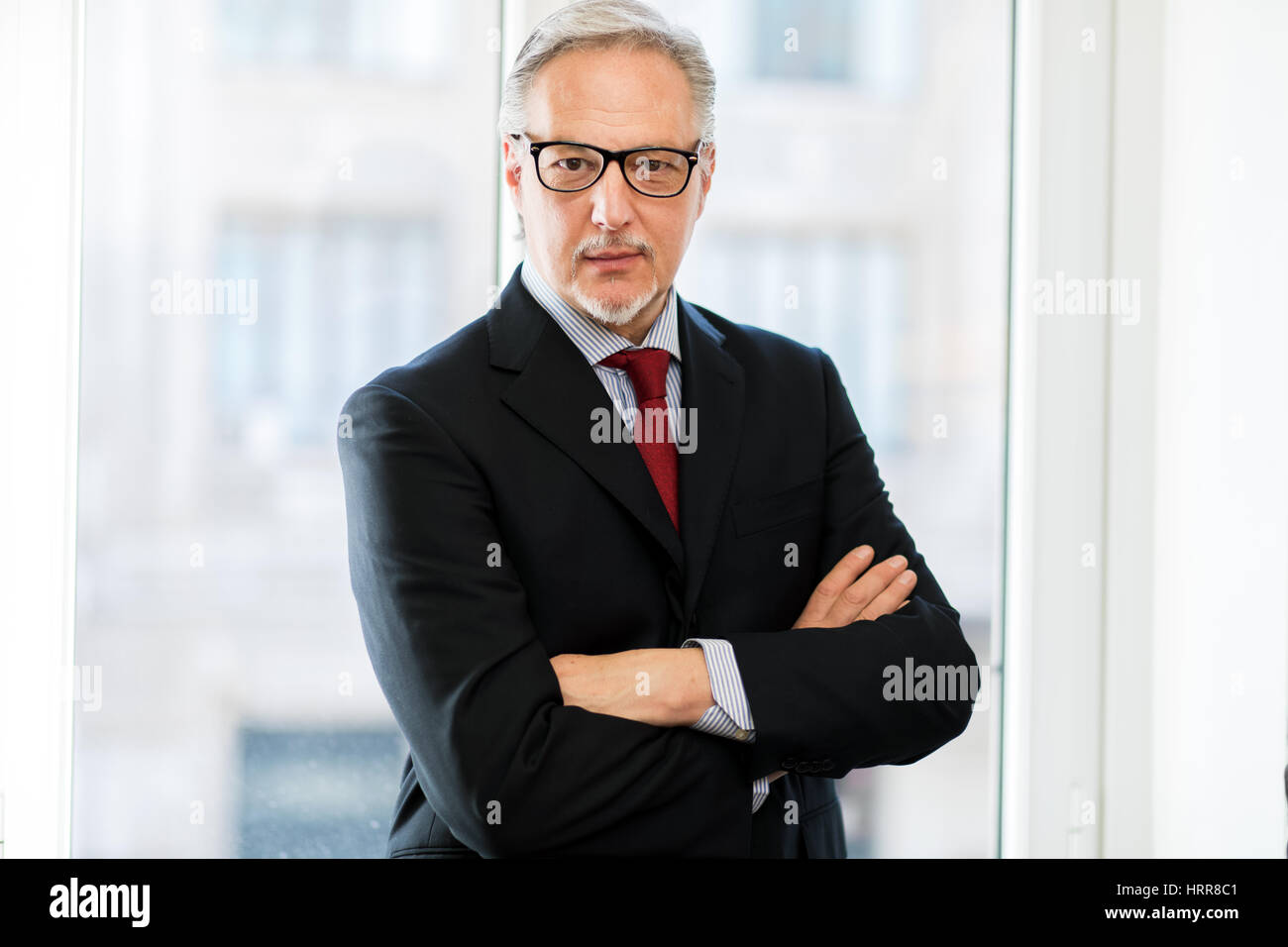 Smiling businessman in his office Stock Photo - Alamy