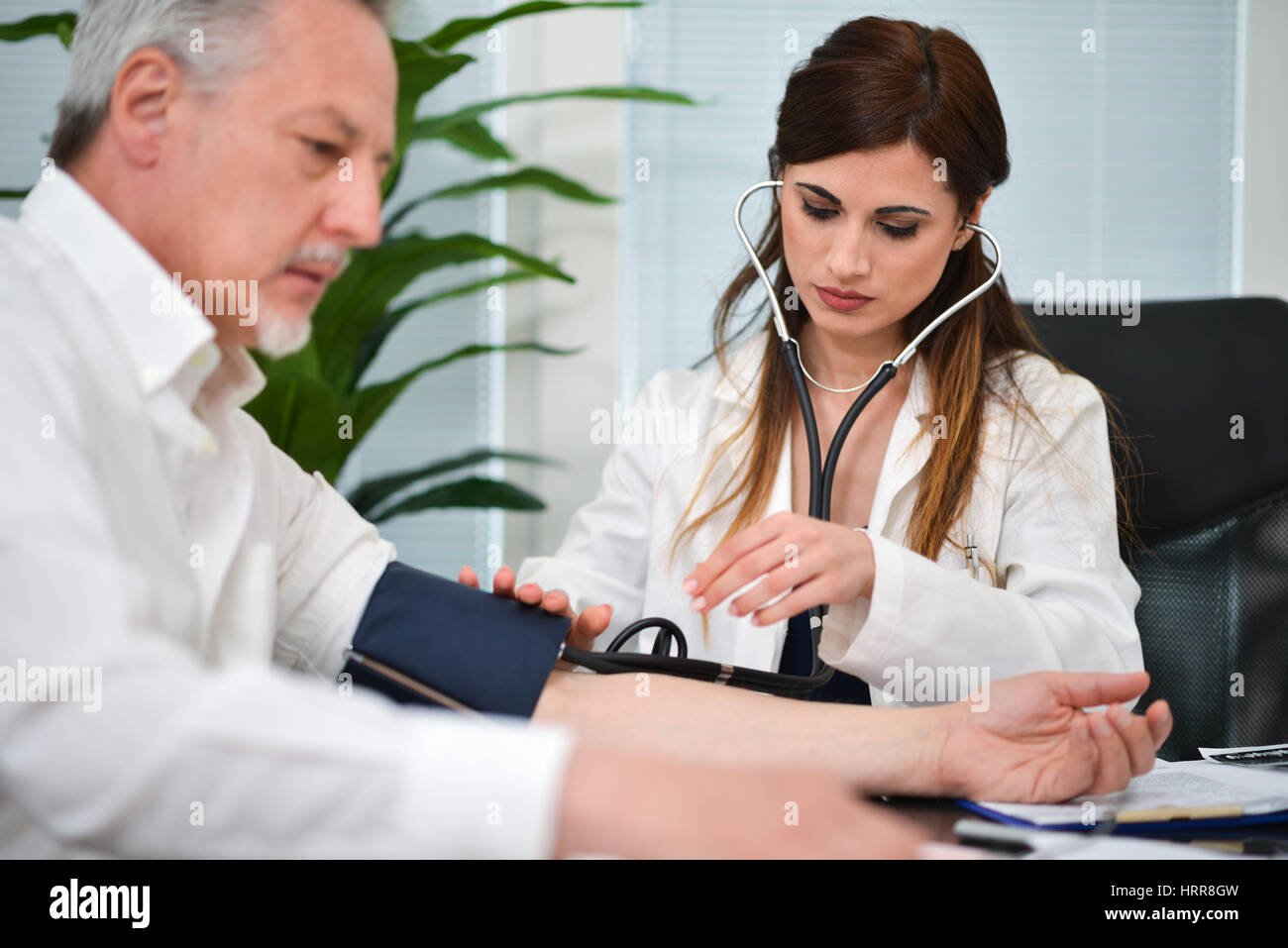 Doctor checking blood pressure to a patient Stock Photo - Alamy