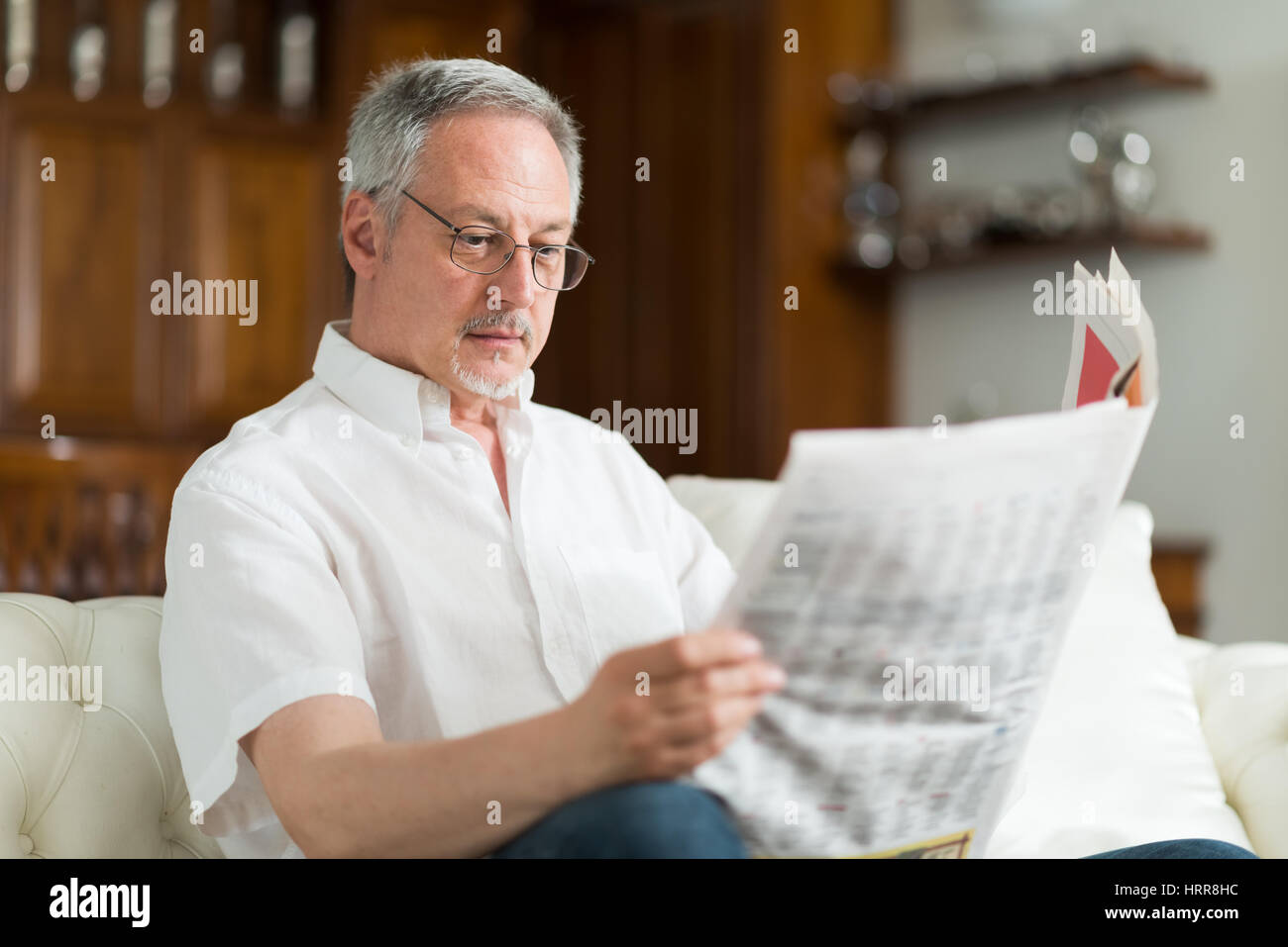 Portrait of a mature man reading a newspaper Stock Photo