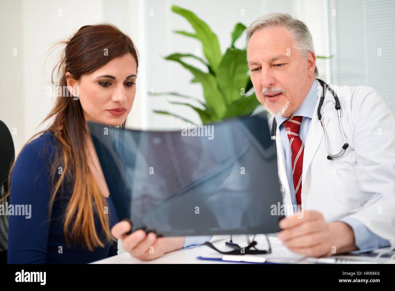 Smiling doctor showing a radiography to his patient Stock Photo - Alamy