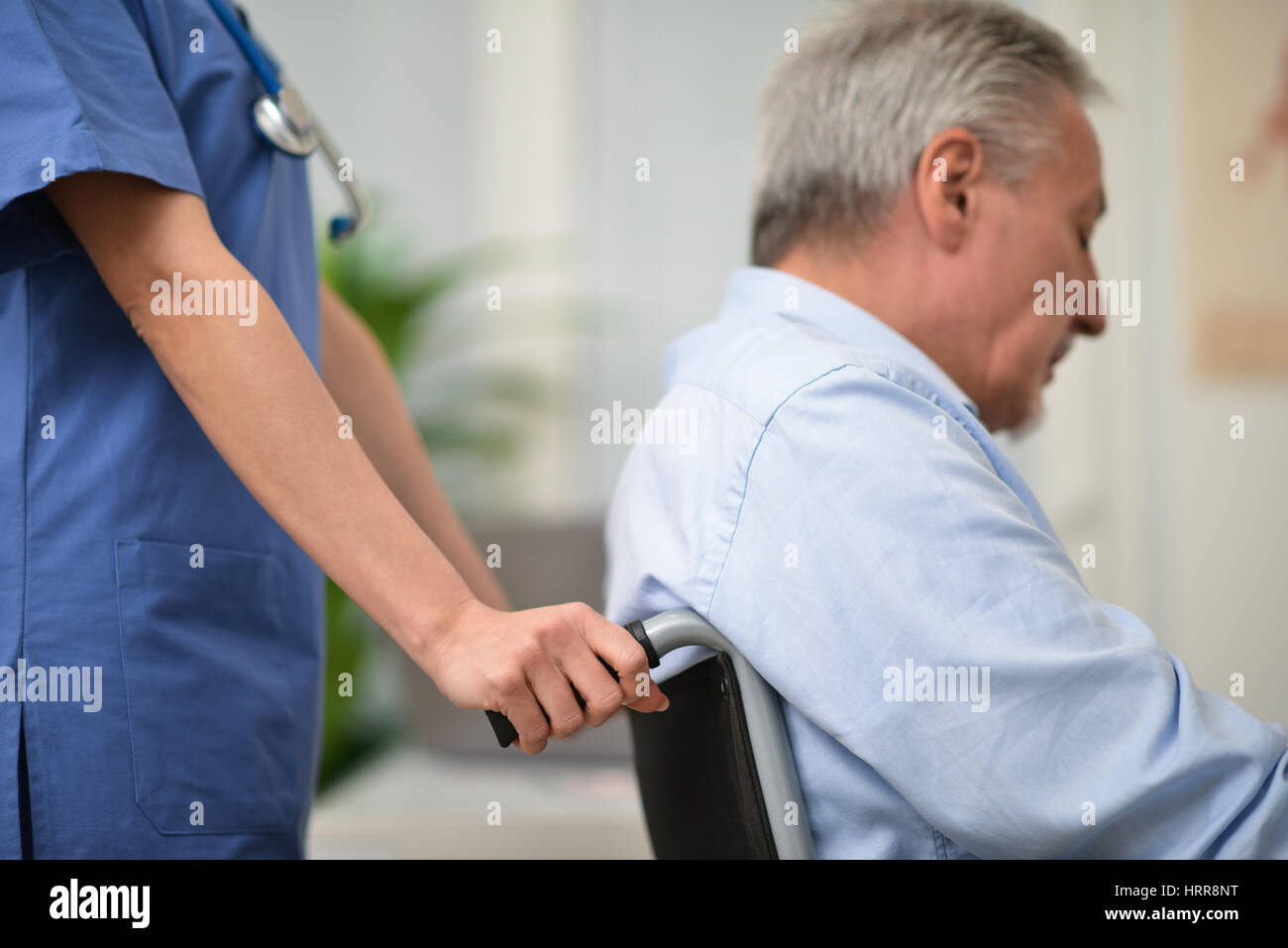 Nurse pushing an injured patient on a wheelchair Stock Photo - Alamy