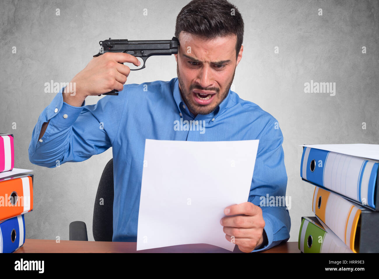 Businessman pointing a gun to his head Stock Photo