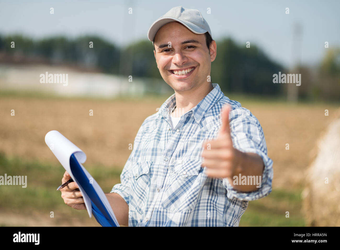 Portrait of a smiling farmer giving thumbs up Stock Photo - Alamy