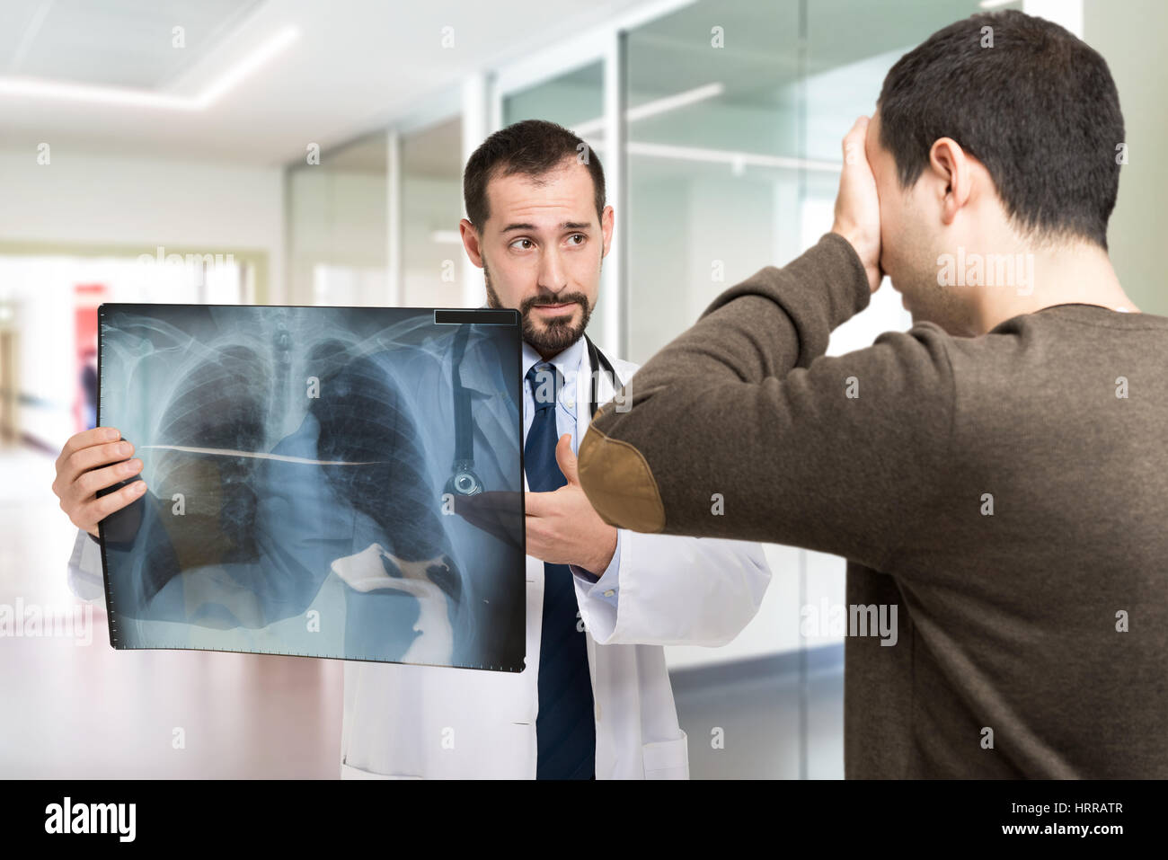 Doctor showing a radiography to a desperate patient Stock Photo