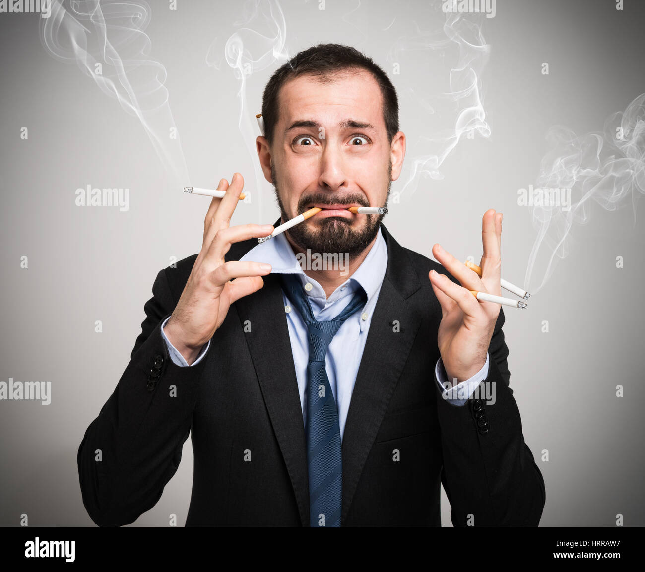 Nervous man smoking a lot of cigarettes at once Stock Photo - Alamy