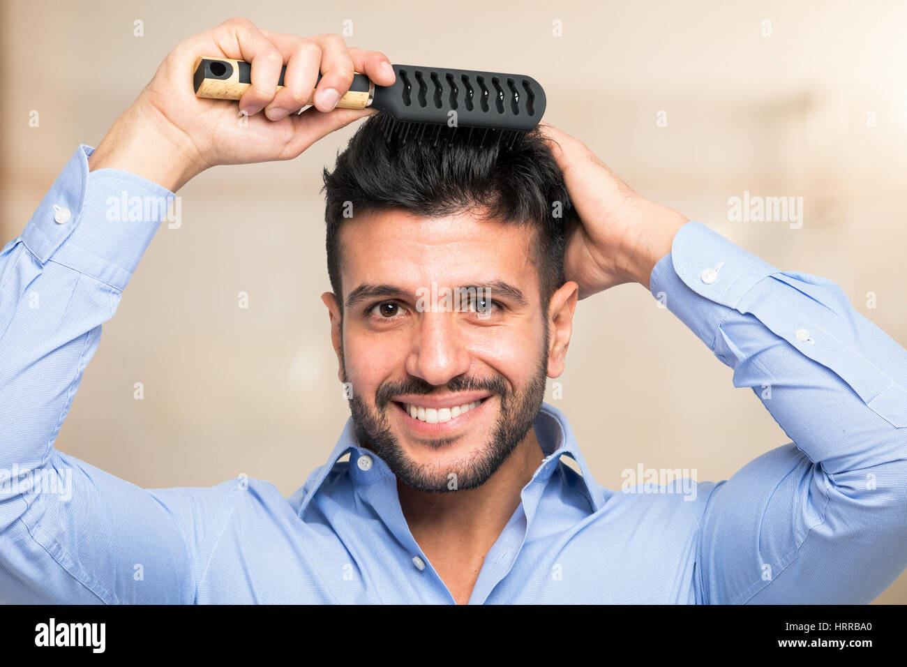 Happy man combing his hair Stock Photo Alamy