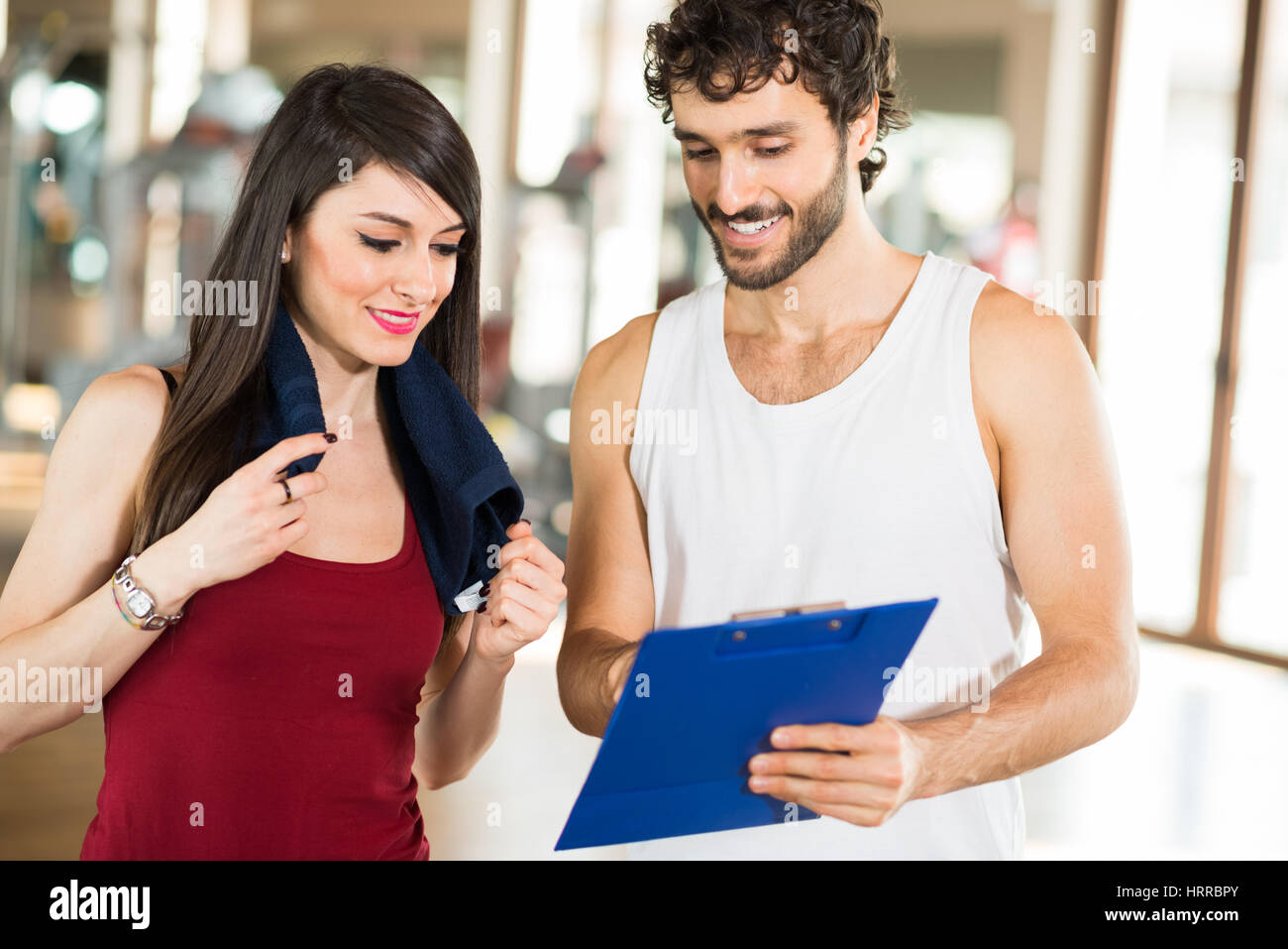 Woman talking to her personal trainer in a gym Stock Photo - Alamy