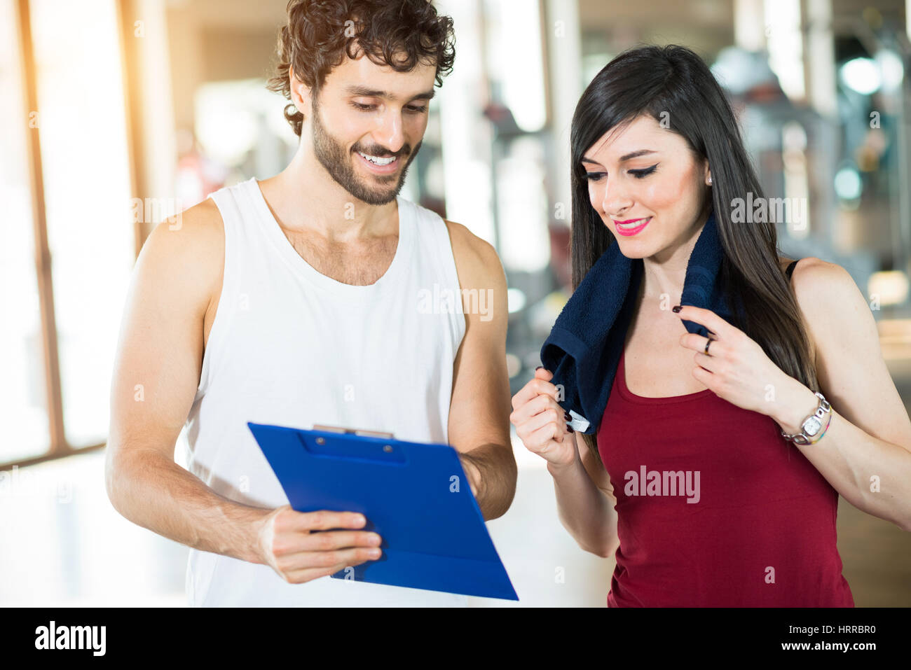 Personal trainer showing the training program to a woman in a gym Stock ...