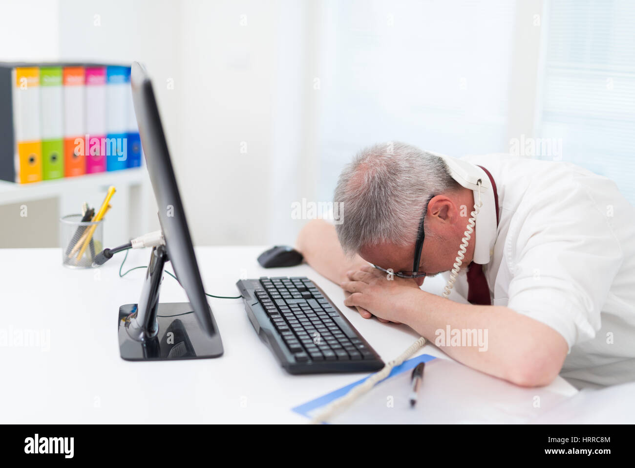 Sad Businessman Lying His Face Down On His Desk Stock Photo