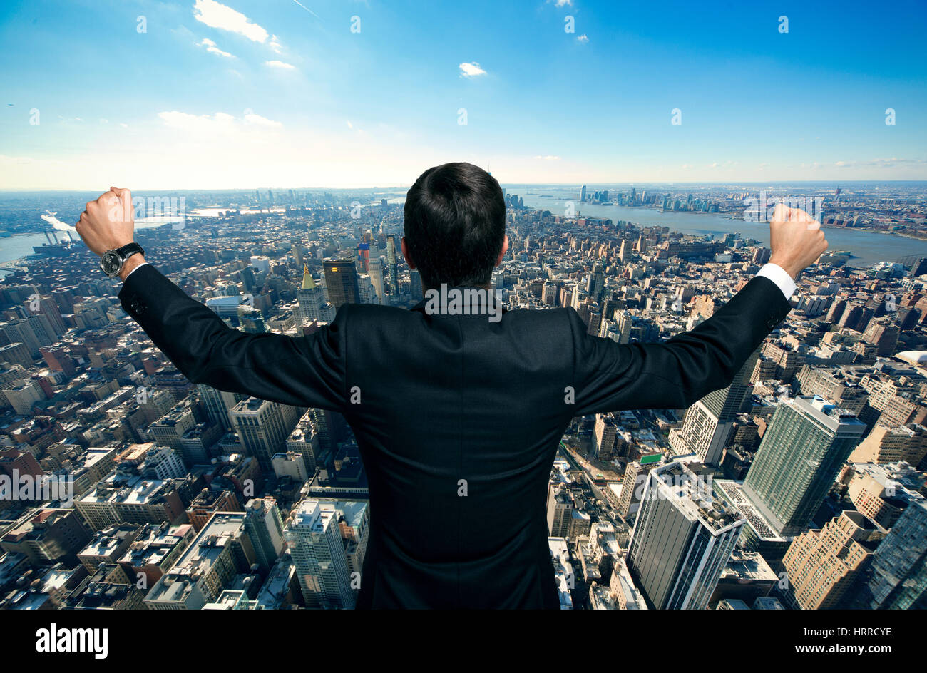 Happy businessman raising his arms in front of a big city Stock Photo ...