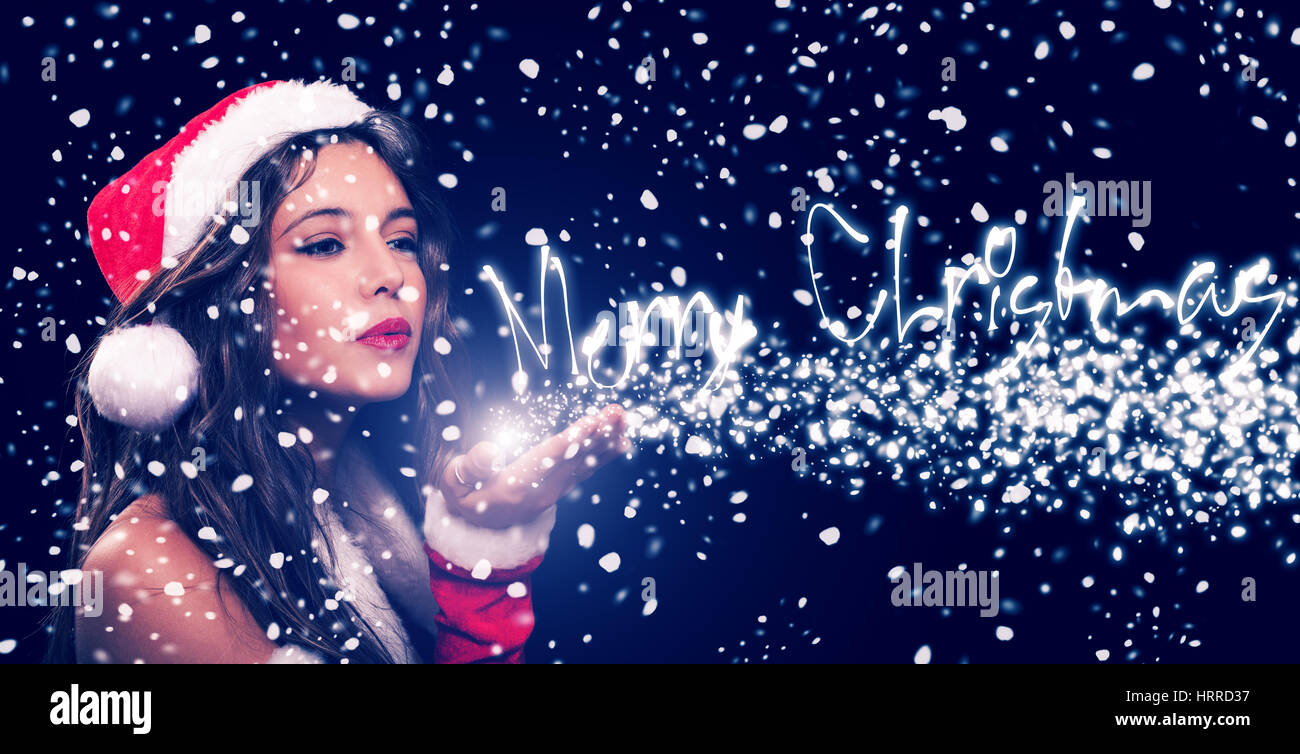 Christmas woman blowing snow from her hand, merry christmas text Stock Photo