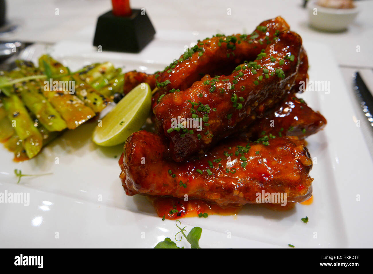 Spicy glazed ribs with an herbal dressing and asparaguses Stock Photo