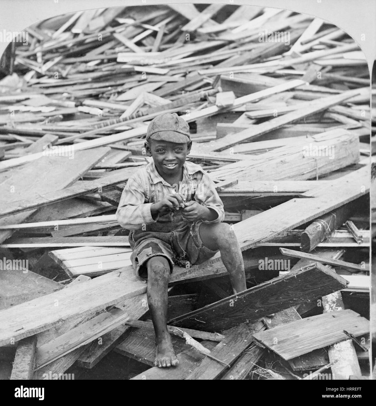Portrait of Young Boy Sitting on Pile of Debris after Hurricane, Galveston, Texas, USA, Single Image of Stereo Card, 1900 Stock Photo