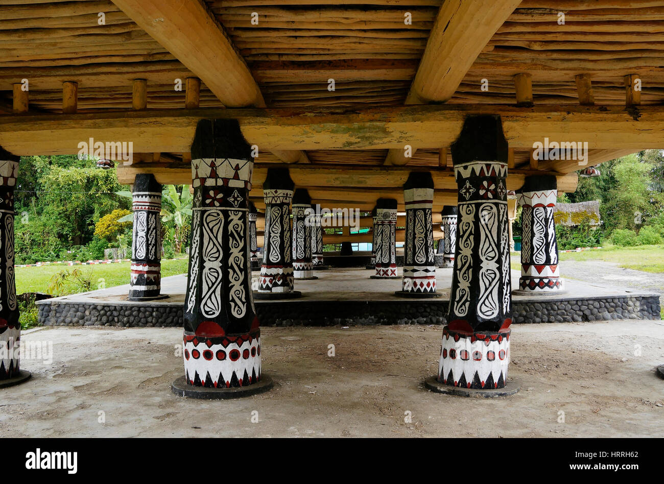Black pillars with white drawings underneath a house at an old Batak village in Sumatra Samosir Island in the afternoon, Indonesia. Stock Photo