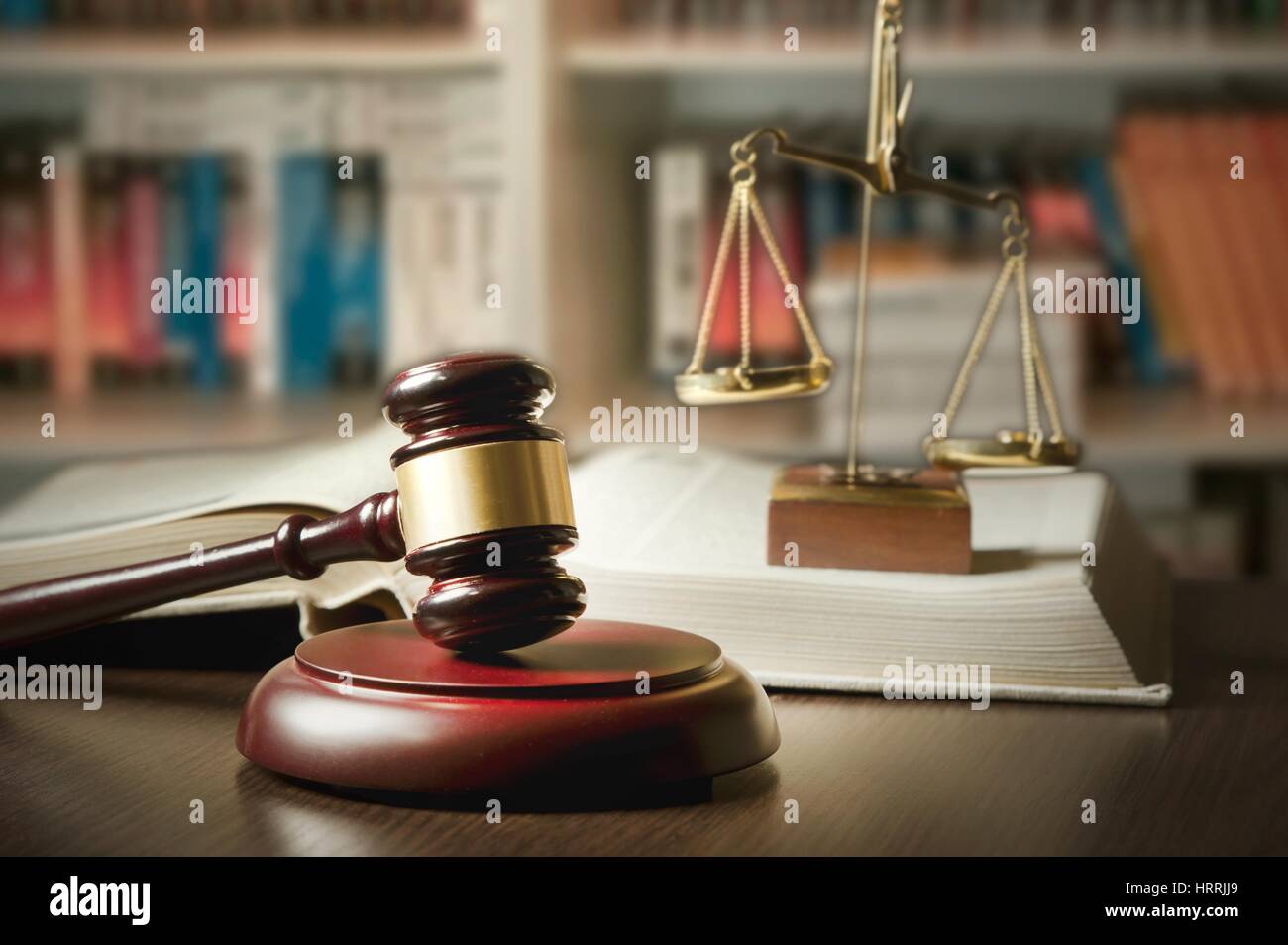 Judge gavel and scale in court. Library with lot of books in background Stock Photo