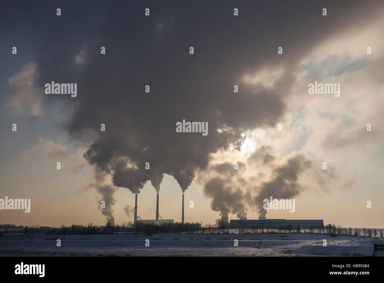 Silhouette of coal plant with gray smoke. Environment pollution by power plants. Perfect industrial background. Free space for text on gray smoke back Stock Photo
