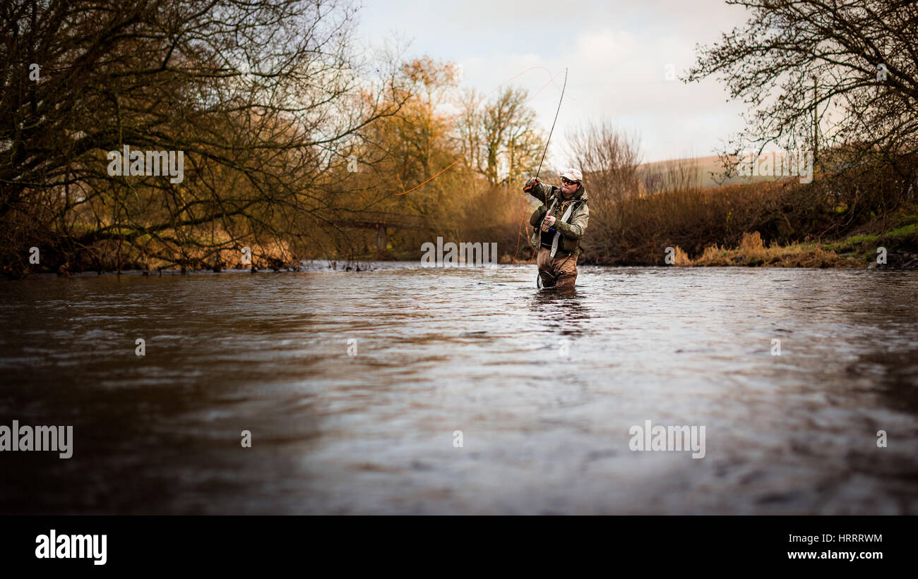 Fly fisherman wading into the river, fly fishing for trout Stock Photo