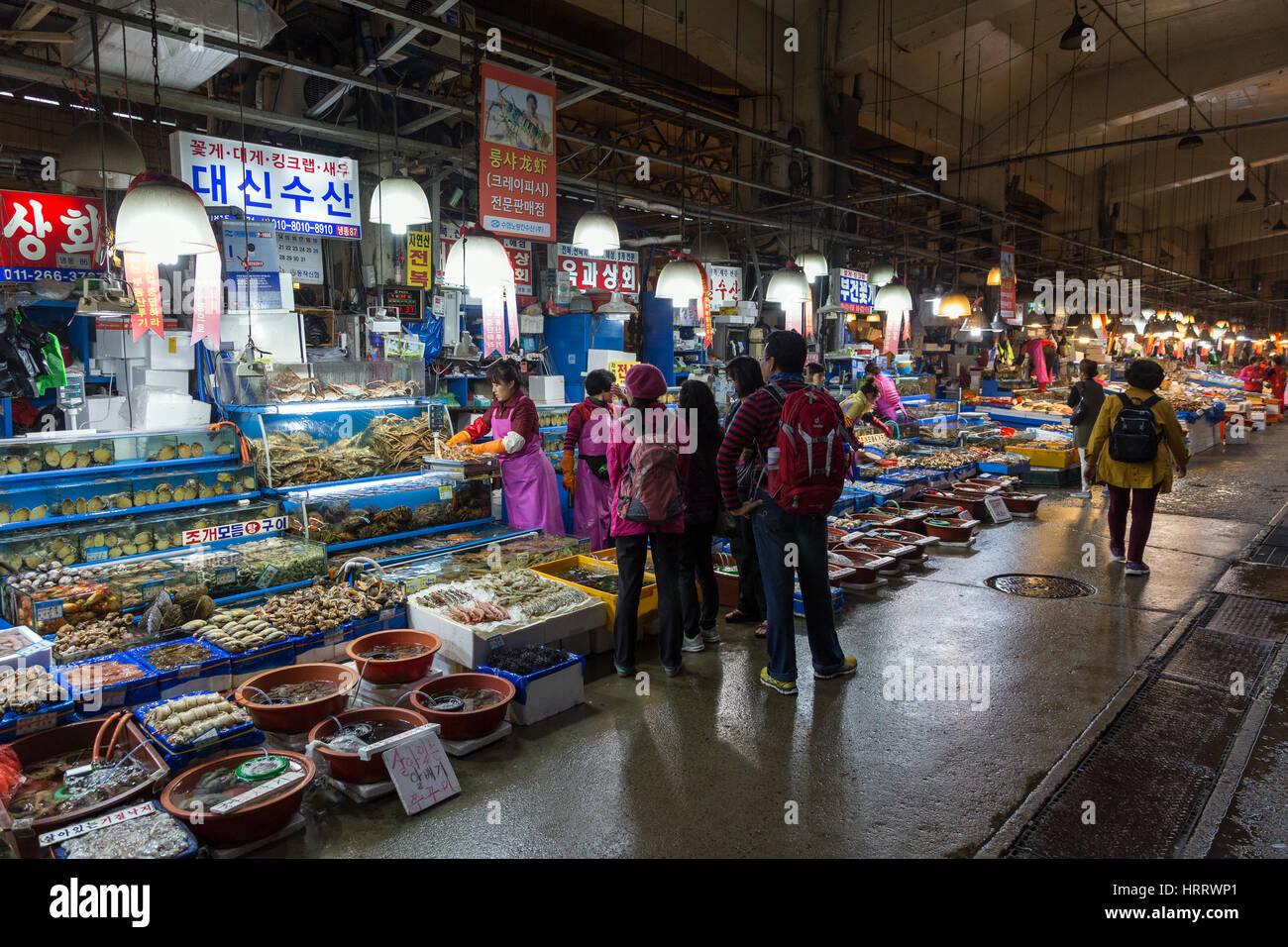 All kind of seafood in water tanks and containers and people in front of them at the Noryangjin Fish Market in Seoul, South Korea. Stock Photo